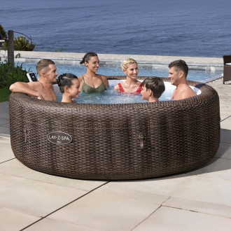 Nafukovacie jacuzzi LAY-Z-SPA® BALI SMART AIRJET™ v hnedom ratanovom prevedení s ľuďmi na terase pri mori