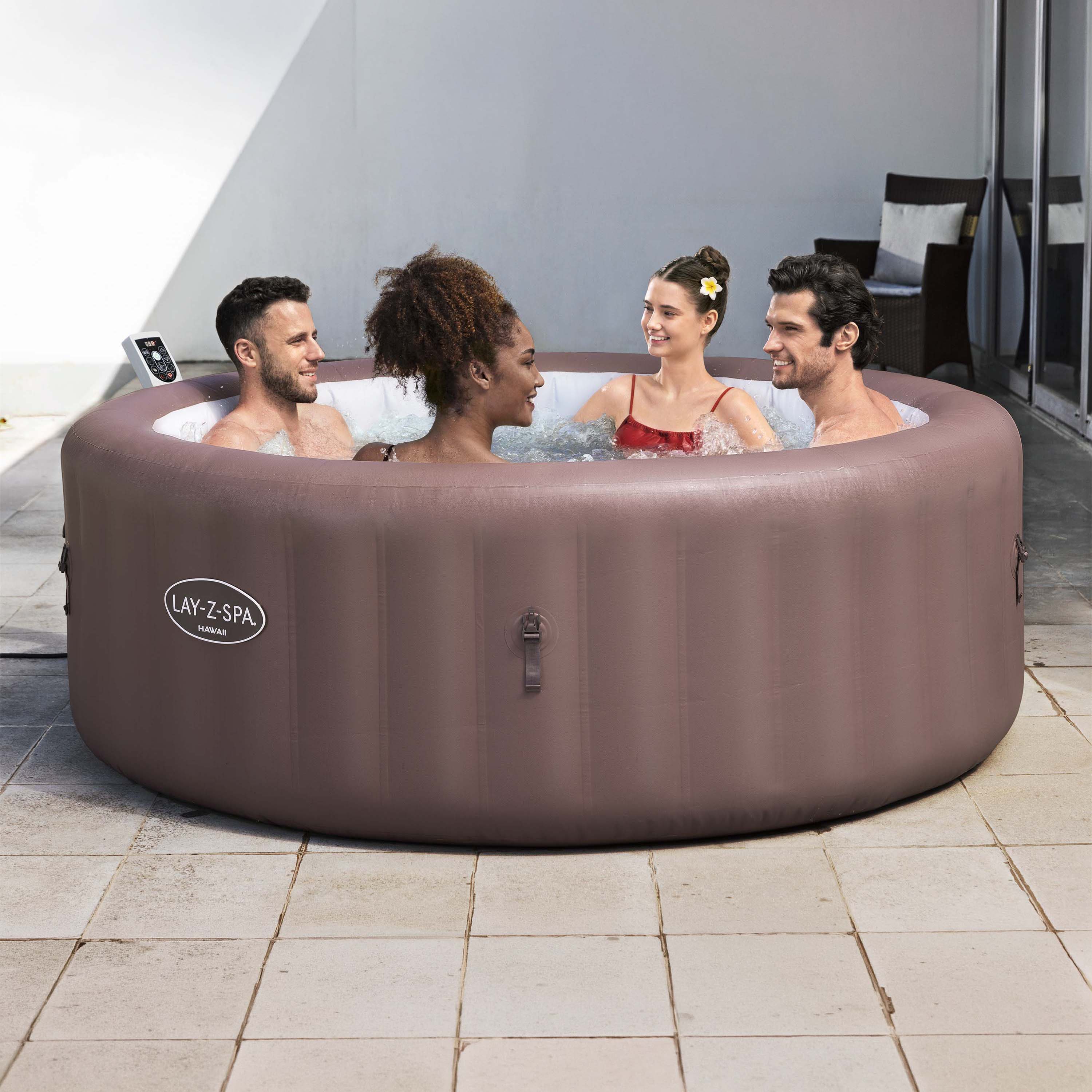Štyria ľudia relaxujú v okrúhlej nafukovacej vírivke LAY-Z-SPA® HAWAII SMART AIRJET™ vo farbe terracotta na terase