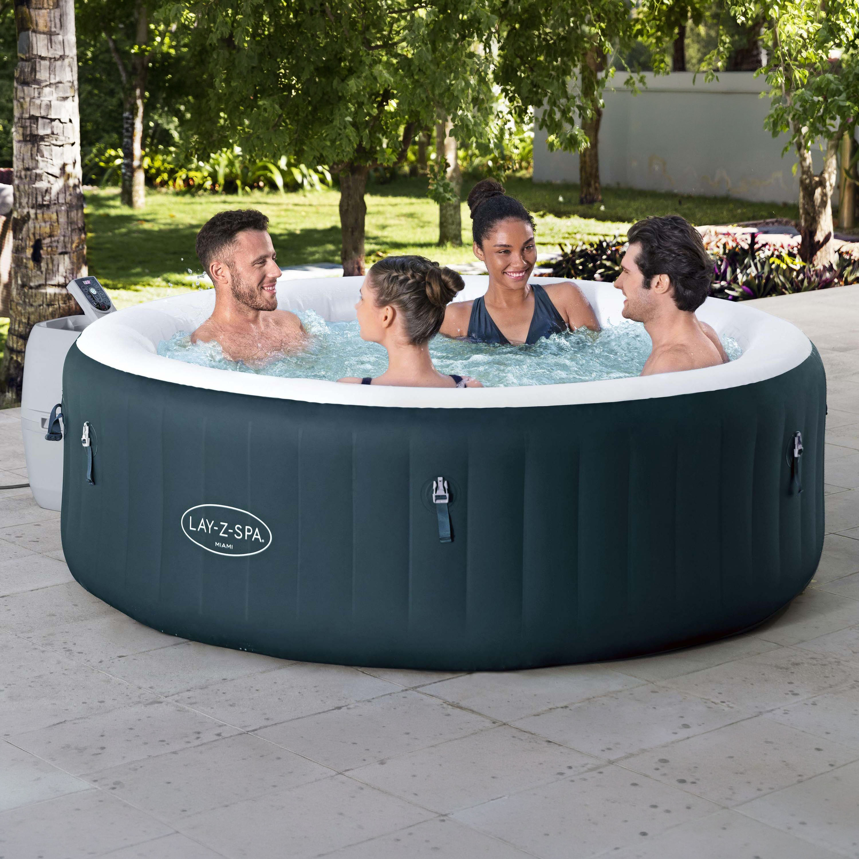 Nafukovacie jacuzzi LAY-Z-SPA Miami AirJet v tmavej zelenej farbe so štyrmi ľuďmi vo vírivke na záhradnej terase