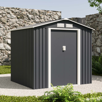 Záhradný plechový domček VECTOR 7x6 Cold Grey od Hardmaister v sivej farbe umiestnený na štrkovom podklade pri kamennom múre