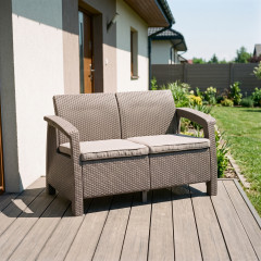 Sofa ogrodowa CORFU LOVE SEAT w kolorze beżowym, pokryta polipropylenem we wzorze imitującym naturalny rattan