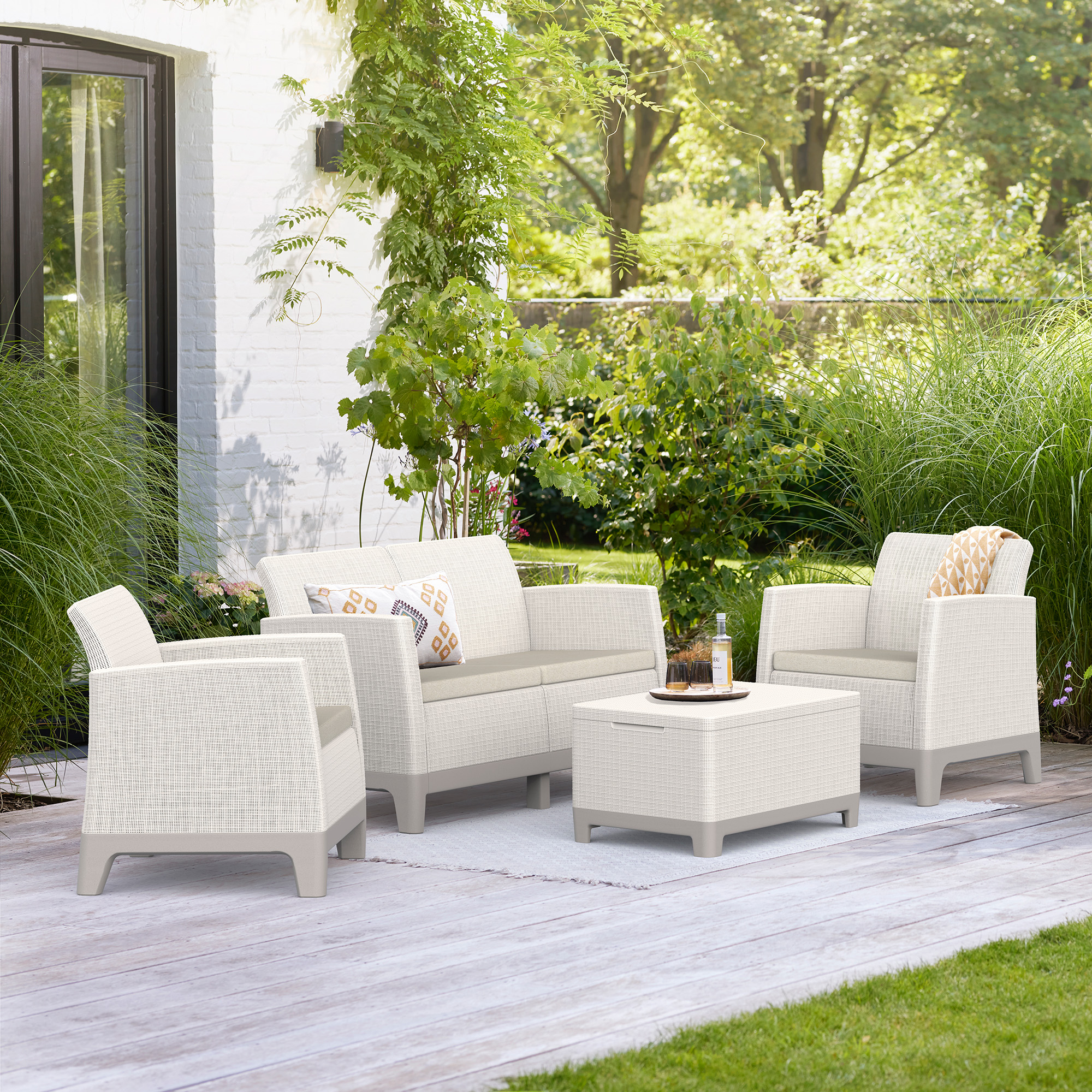 Záhradný set nábytku Scandi Forma Pebble Grey-Soft Beige v aranžmáne na terase s vankúšmi a nízkym stolíkom
