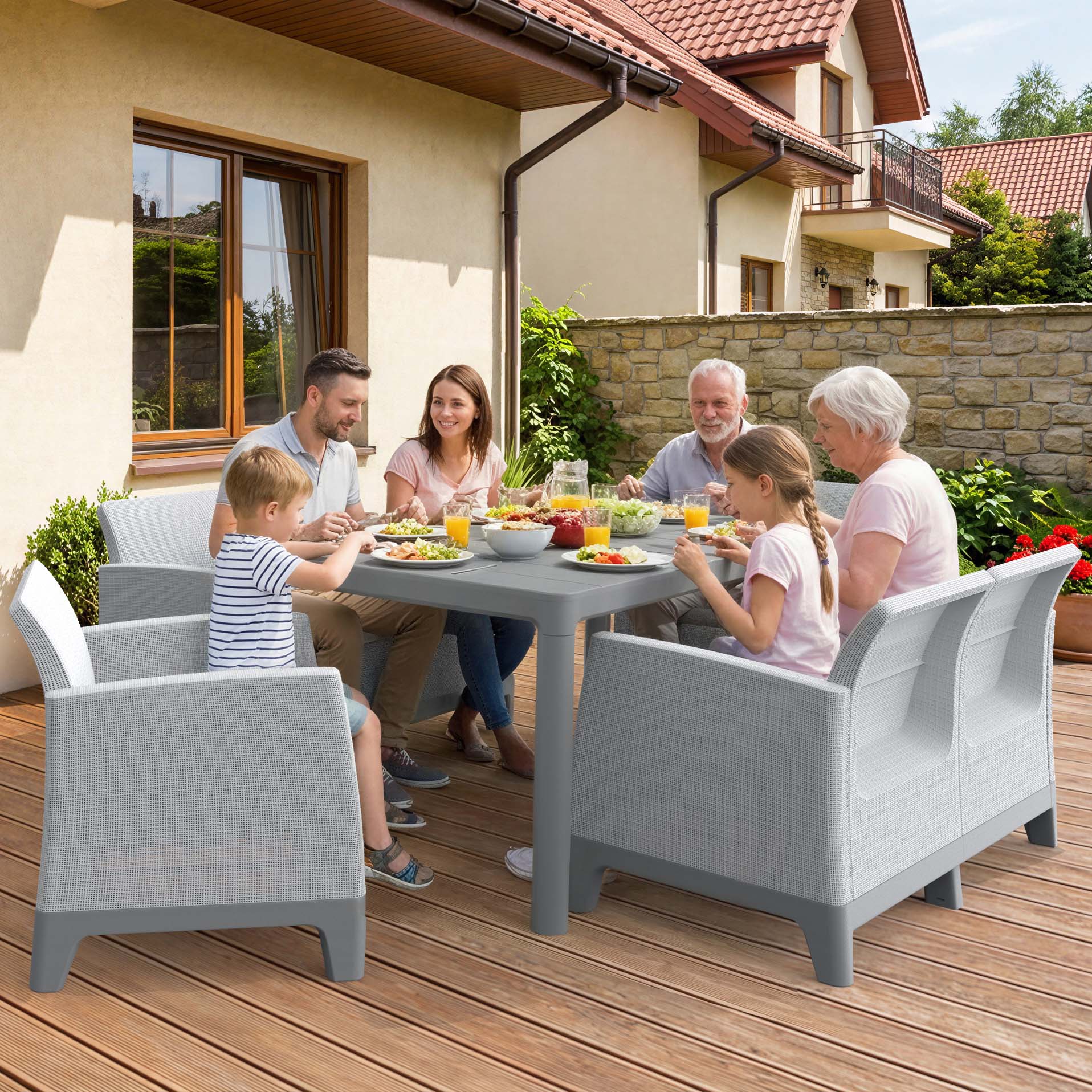 Šesťčlenná rodina stoluje na terase pri sivom záhradnom sete Keter Scandi Dining Fiesta s jedálenským stolom a stoličkami