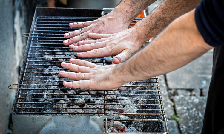 muži kontroluj&uacute;ci teplotu grilu rukami