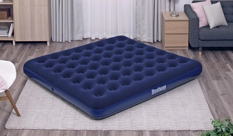 Materac pompowany KING granatowy w salonie na podłodze 