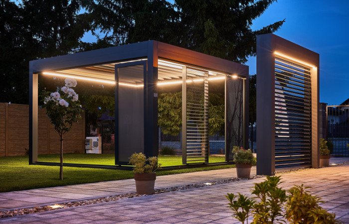 z&aacute;hradn&aacute; pergola s kr&aacute;snym osvetlen&iacute;m a kompletn&yacute;m pr&iacute;slu&scaron;enstvom v podobe zrolovacej rolety a žal&uacute;ziov&yacute;ch panelov na bočn&yacute;ch sten&aacute;ch